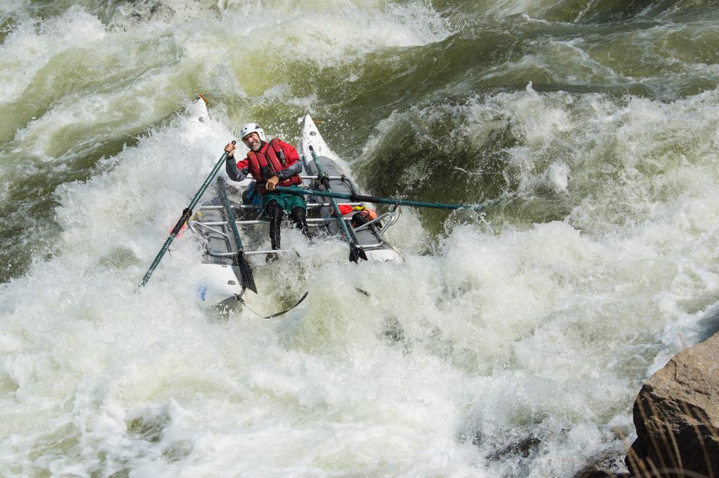 Two adventurers tackling the challenge of tumultuous white water rapids in a Wave Destroyer raft.